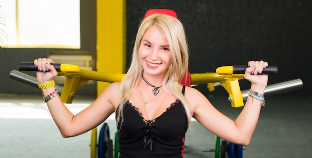 Женщина фитнеса выполняет упражнение с тренажером в тренажерном зале