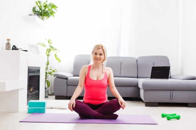 Donna fitness che si esercita sul pavimento a casa