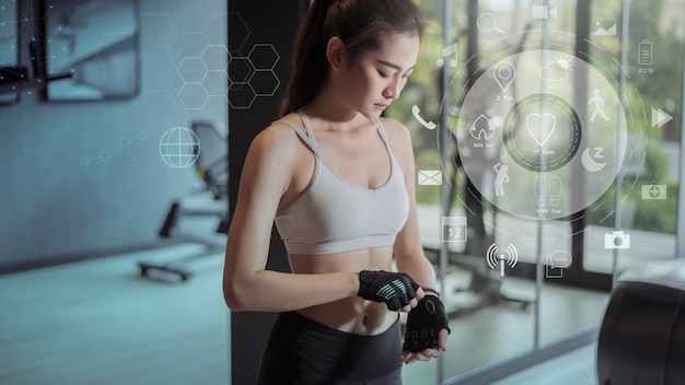 Fitness woman in gym with workout icons, health care technology concept