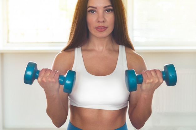 Photo fitness woman holding dumbbells