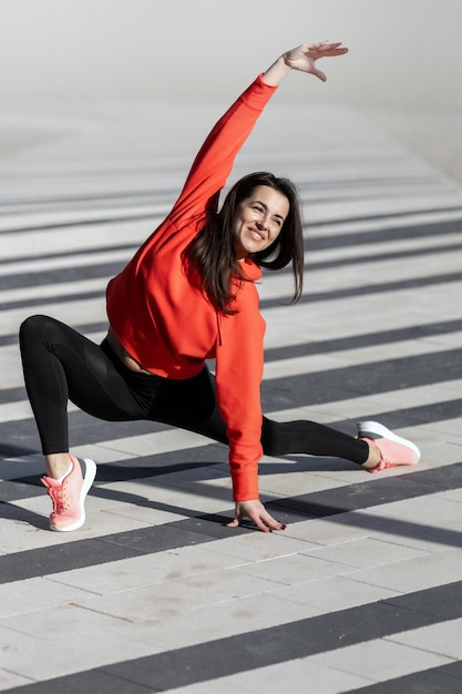 Fitness woman is fitness stretching and exercising outdoor in urban environment