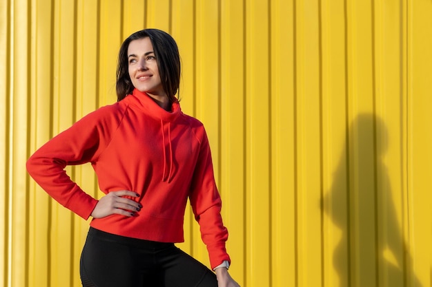 Fitness woman is fitness stretching and exercising outdoor in yellow wall urban environment