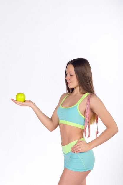 Fitness woman looks at apple