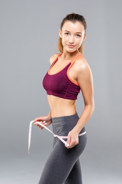 Fitness Woman measuring her body isolated. Weight loss concepts
