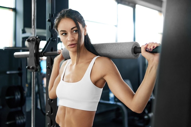 Fitness woman performing an exercise with a barbell