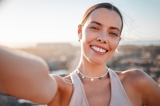 Fitness woman and portrait smile for profile picture selfie or vlog by beach for healthy exercise Happy female runner smiling with teeth for social media memory or post by ocean coast outdoors