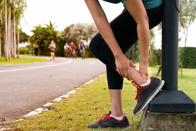 Fitness woman runner feel pain on ankle leg