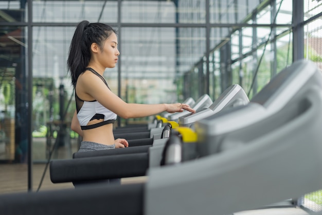 Fitness woman running with exercise-machine in gym