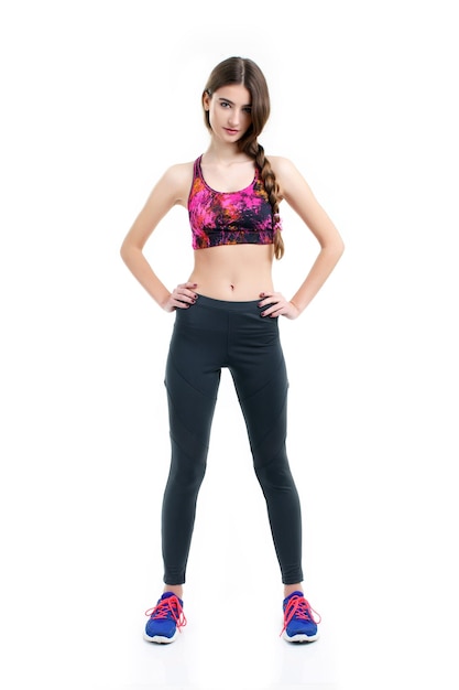 Fitness woman in sport style standing against white background