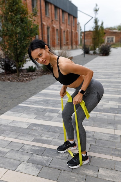 Fitness woman using a rubber expander band during workout exercise