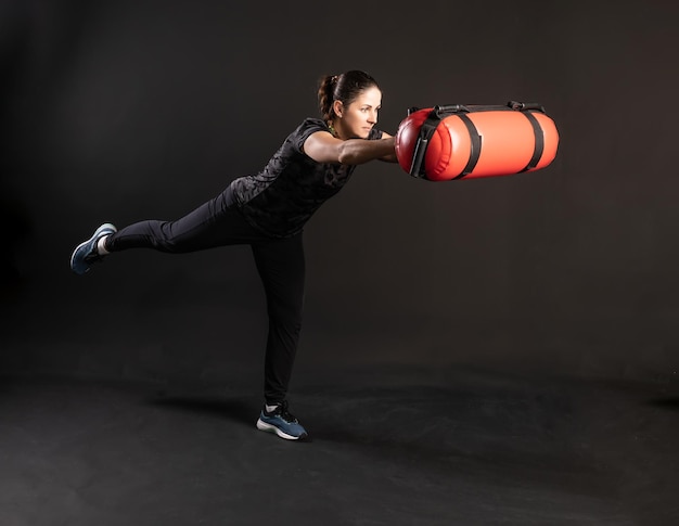 Fitness woman with Aqua Bag stretches out her arms and holds her leg Engaged in sports on a