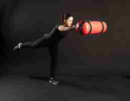 Photo fitness woman with aqua bag stretches out her arms and holds her leg engaged in sports on a