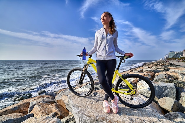 Fitness woman with yellow bicycle