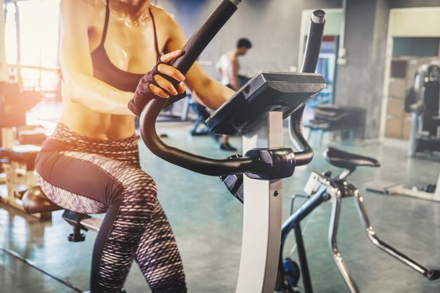 Foto donna di forma fisica che risolve sulla bici di esercizio in palestra