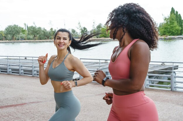 Photo fitness women running together. feminist women training in sportswear of different nationality.