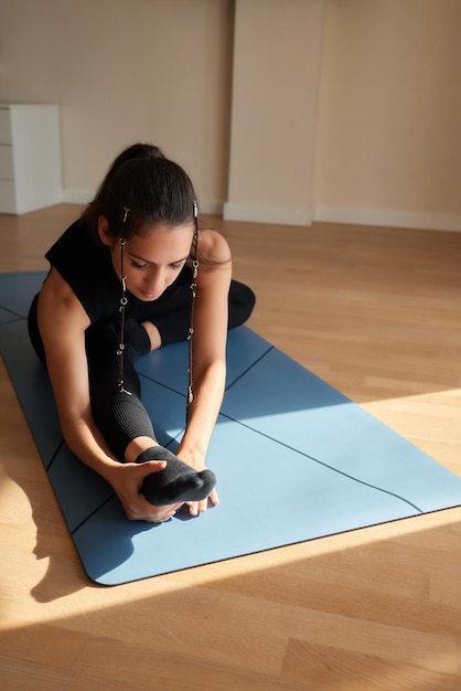 Photo fitness workout girl squats on the mat at home view from the side