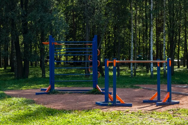 Foto fitnessapparatuur in het park tussen de bomen