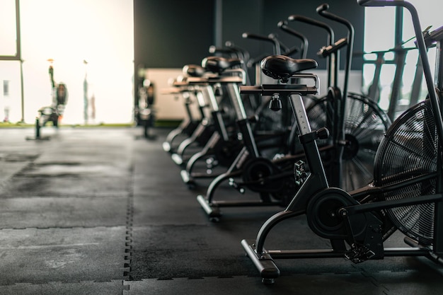 Fitnessapparatuur Stationaire fietsen staan op een rij bij lege sportschool