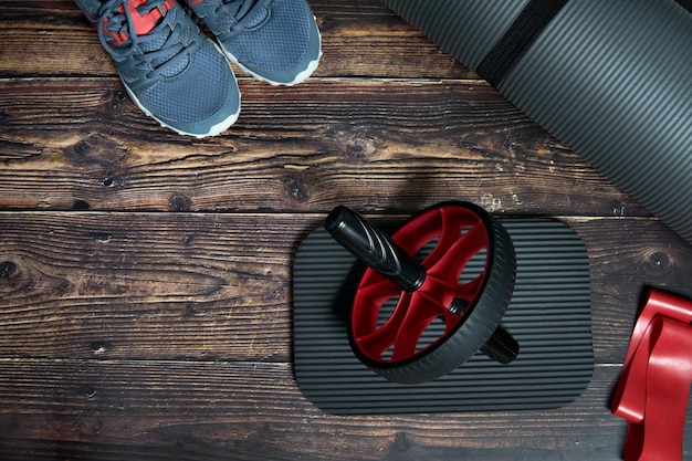 Fitnessapparatuur voor sportschool en thuis Mat fitness wielband sneakers op donkere houten achtergrond
