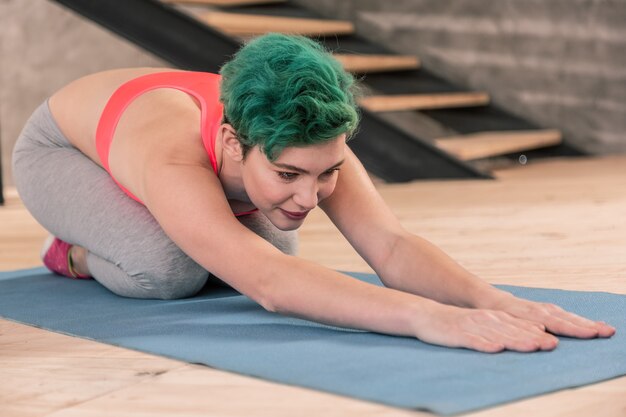 Fitnessen bijwonen. Mooie groenharige vrouw met roze top die naar het fitnesscentrum gaat na het werk