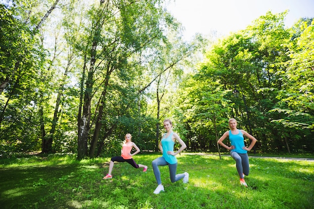 Fitnessgroep doet yoga in park op een zonnige dag