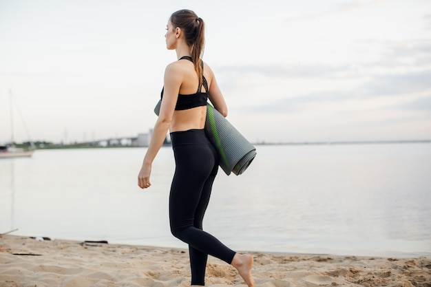 Fitnessmodel gaat sporten op het strand