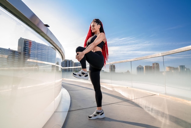 Fitnessoefening en een vrouw die zich uitstrekt in de sportschool tijdens opwarmtraining en training voor gezondheid en welzijn Sportvrouw of atleet op de grond om de benen te strekken om flexibel, evenwichtig en gezond te zijn