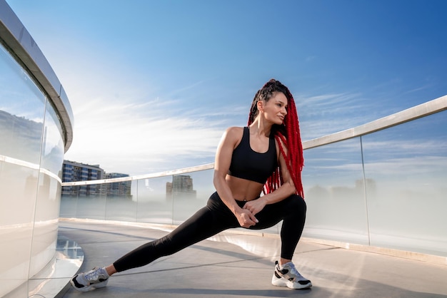 Fitnessoefening en een vrouw die zich uitstrekt in de sportschool tijdens opwarmtraining en training voor gezondheid en welzijn Sportvrouw of atleet op de grond om de benen te strekken om flexibel, evenwichtig en gezond te zijn