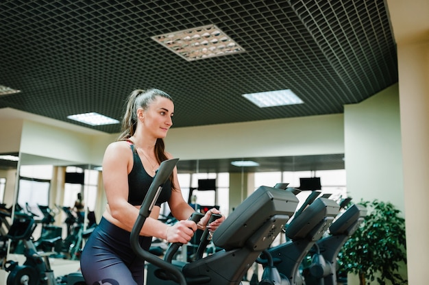 Fitnesstrainer meisje houdt zich bezig met sporten in de sportschool.