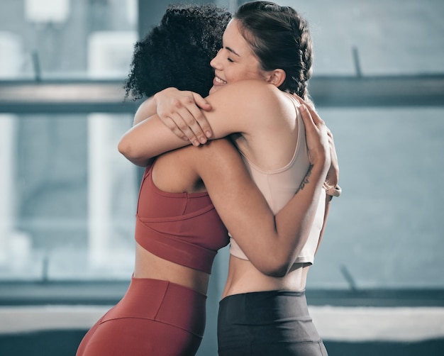 Fitnessvrienden en knuffelen met vrouwen in de sportschool voor een prettige training en training Goed gedaan gefeliciteerd en steun met vrouwelijke atleet die samen traint voor een sportmentaliteit en wellnessmotivatie