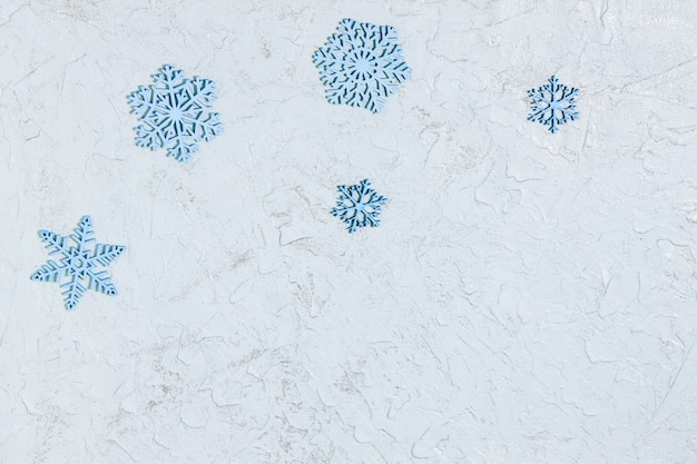 Five blue wooden snowflakes on glitter surface