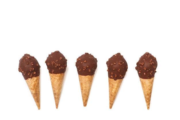 Five chocolate ice cream cones with almond chips on a white wall