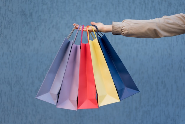 Five colored bags for shopping in a female hand. Close-up. Shopping