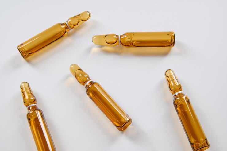 Five dark glass ampoules with medicine lie on a white background Top view