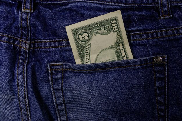 Five dollars banknote in the pocket of blue jeans