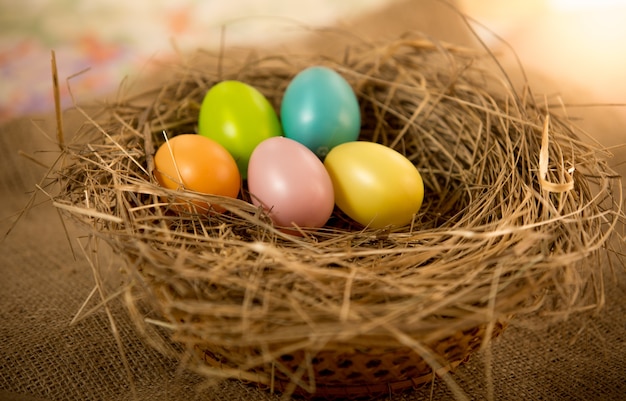 Пять пасхальных яиц, лежащих на столе в гнезде