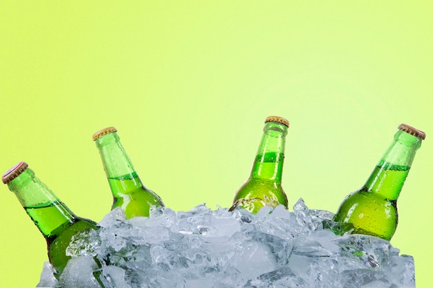 Five fresh beer bottles in stack of ice cubes