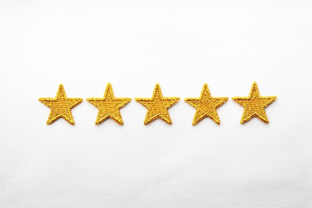 Five gold stars embroidered on white cloth