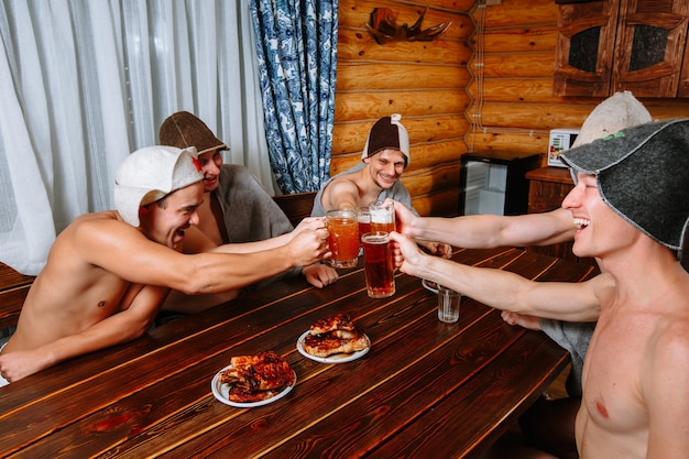 Five guys relax in the sauna after the steam room and drink beer