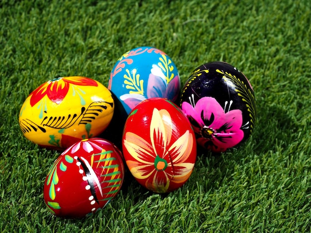 Five hand colored easter eggs on green grass