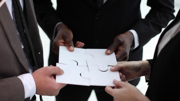 five hands of businessmen put together a puzzle