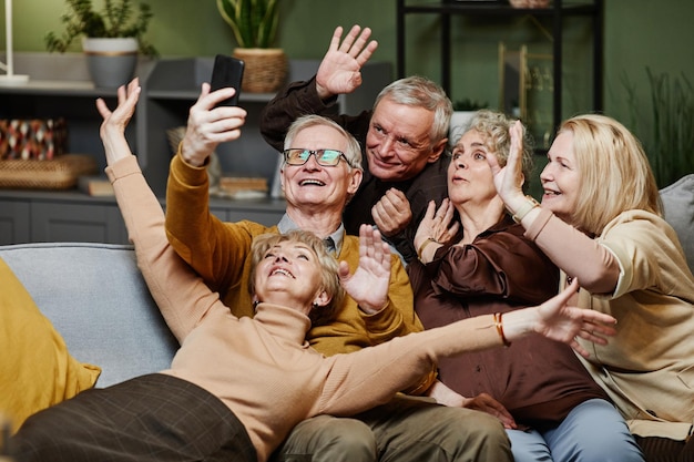 Five happy aged friends making selfie