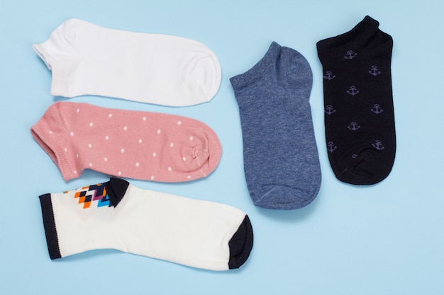 Five pair of multi-colored cotton women socks on a blue background, Top view.