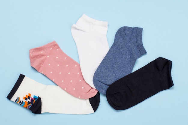 Five pair of multi-colored women socks on a blue background, Top view.