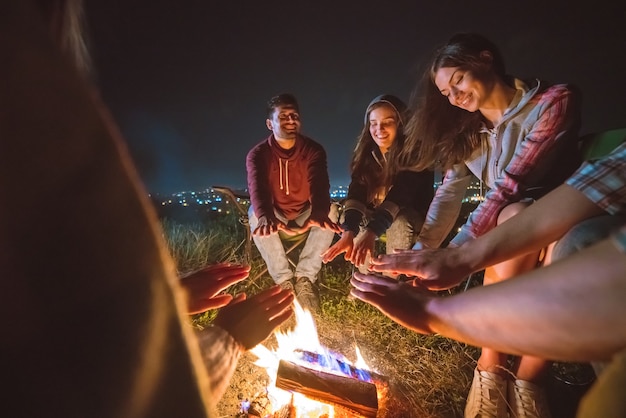 The five people warming hands near the bonfire. night time