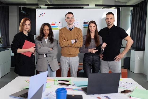 Five successful people pose in the office A young team of a successful startup in the office