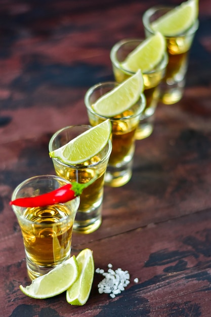 Foto cinque colpi di tequila con snack lime e pistacchio, sale e peperoncino per la decorazione, vodka, whisky, rum