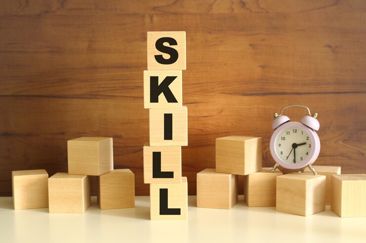 茶色の背景に垂直に積み重ねられた5つの木製の立方体がSKILLという言葉を構成しています