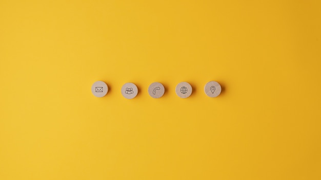 Five wooden cut circles with contact and information icons on them placed in a row