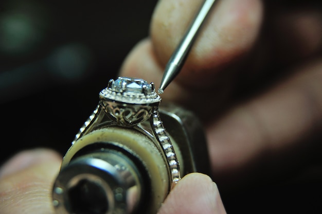 Photo fixing a gem into a jewelry ring during the manufacturing process